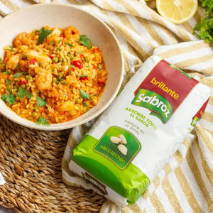 A plate of shrimp and vegetable rice garnished with parsley, beside a Sabroz round rice package